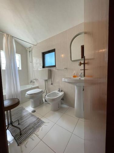 a white bathroom with a sink and a toilet at Casa Morais in Vinhais