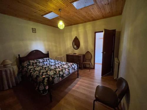 1 dormitorio con cama, mesa y espejo en Casa Morais, en Vinhais