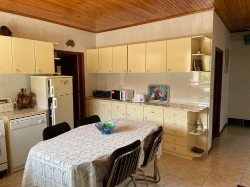 eine Küche mit einem Tisch mit Stühlen und einem Kühlschrank in der Unterkunft Casa Morais in Vinhais