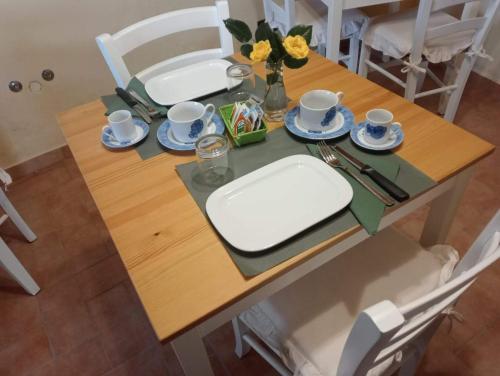 una mesa con dos platos y tazas encima en B&B La Rocchetta dal Sròz, en Le Serucce