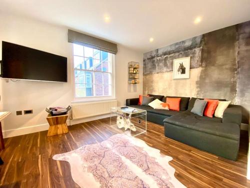 a living room with a couch and a flat screen tv at Stunning Little House on Poole Quay - Free Secure Parking & WiFi - in the heart of the Old Town - Great Location - Free Parking - Fast WiFi - Smart TV - Newly decorated - sleeps 2! Close to Poole & Bournemouth & Sandbanks in Poole