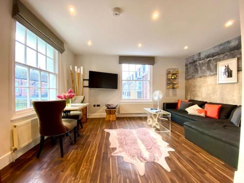 a living room with a couch and a table at Stunning Little House on Poole Quay - Free Secure Parking & WiFi - in the heart of the Old Town - Great Location - Free Parking - Fast WiFi - Smart TV - Newly decorated - sleeps 2! Close to Poole & Bournemouth & Sandbanks in Poole
