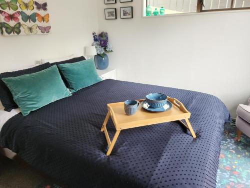 uma cama com uma mesa com duas tigelas em Studio 9 on Lakewood em Wellington