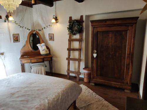 een slaapkamer met een bed, een spiegel en een houten deur bij Feggaropetra Inn Magic Mountain House in Palaios Panteleimon