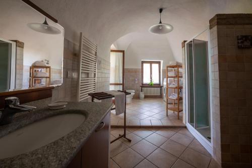 ein großes Bad mit einem Waschbecken und einer Dusche in der Unterkunft VILLA BOTTERA with Jacuzzi in the garden Cuneo Langhe Piemonte in Riforano