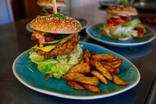 a plate with a hamburger and french fries on a table at Vegan Hotel und Restaurants Nicolay 1881 in Zeltingen-Rachtig