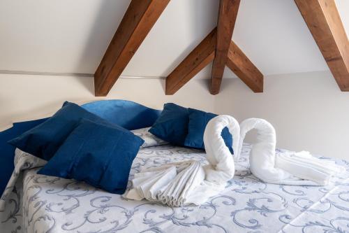 a bed with two swans on it with blue pillows at Hotel Villa Annalara charme and Relax in Amalfi