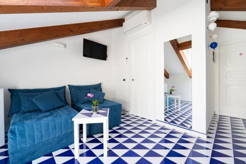 a living room with blue couch and blue and white checkered floor at Hotel Villa Annalara charme and Relax in Amalfi