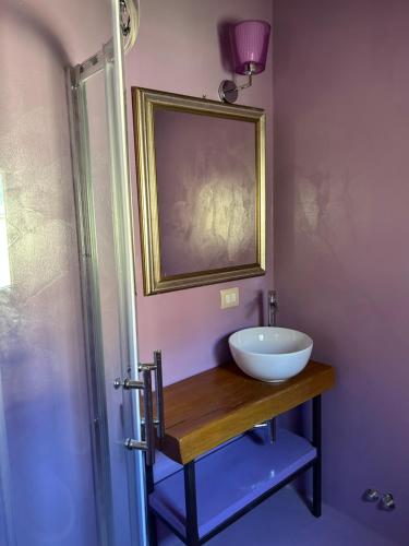 a bathroom with a white sink on a wooden table at matana b&b in Carmignano