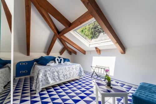 a bedroom with a bed and a blue and white checkered floor at Hotel Villa Annalara charme and Relax in Amalfi