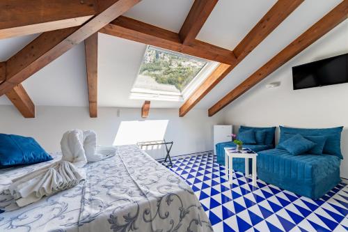 a bedroom with a bed and a couch and a tv at Hotel Villa Annalara charme and Relax in Amalfi