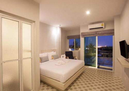 a hotel room with a bed and a balcony at Nature Pine Phuket เนเชอร์ไพน์ภูเก็ต in Rawai Beach