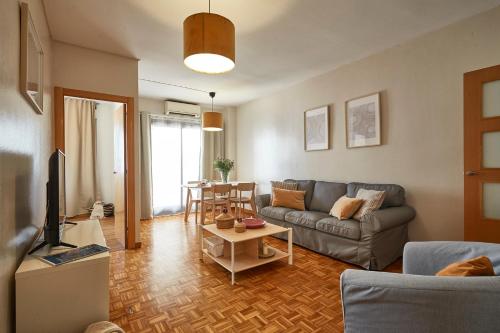 ein Wohnzimmer mit einem Sofa und einem Tisch in der Unterkunft BBarcelona Marina Flat in Barcelona