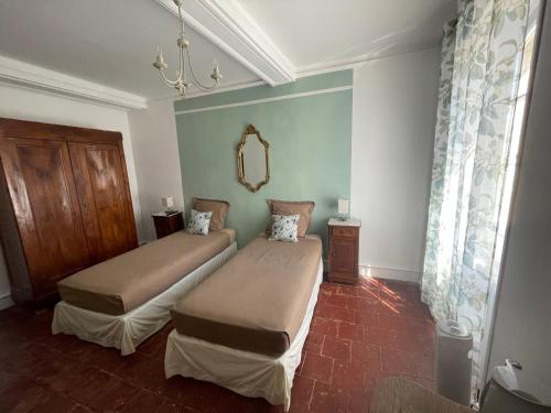 une chambre avec deux lits et un miroir dans l'établissement Maison d'Hotes Le Val d'Aleth, à Alet-les-Bains