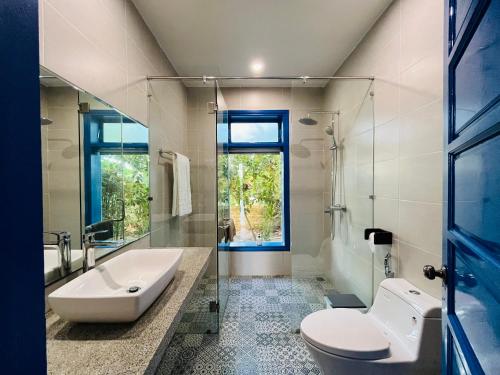uma casa de banho com uma banheira, um lavatório e um WC. em Chez Mimosa Hoi An - LUA Retreat em Hoi An