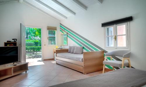 a bedroom with a bed and a tv and a couch at The Grove Seaside Hotel in Dhrepanon