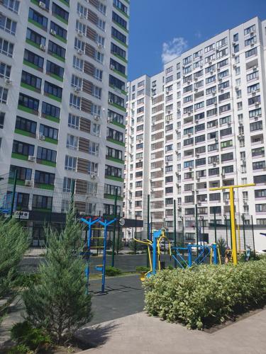 a playground in a park in front of tall buildings at Акварелі 2 in Vyshneve