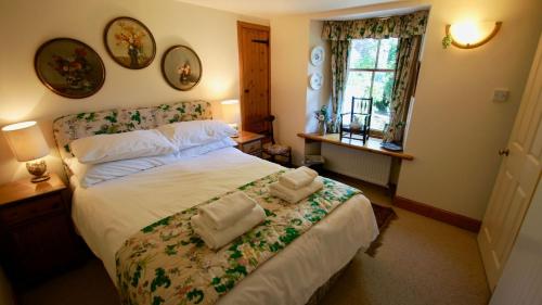 a bedroom with a bed with towels on it at Glen Cottage in Comrie