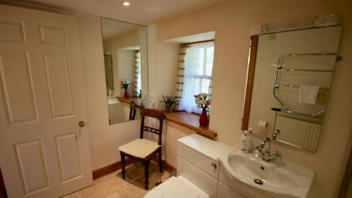 a bathroom with a sink and a mirror at Glen Cottage in Comrie