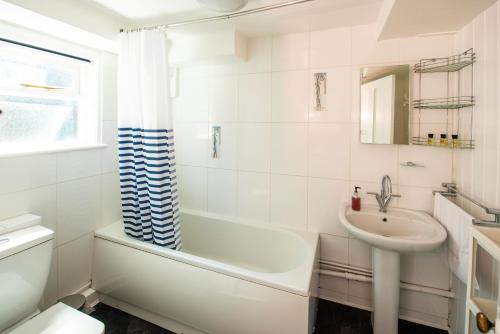 a bathroom with a sink and a tub and a toilet at The Royal Burnham Yacht Club in Burnham-on-Crouch