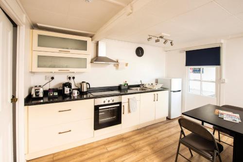 a kitchen with white cabinets and a black counter top at The Royal Burnham Yacht Club in Burnham on Crouch