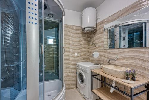 a bathroom with a washing machine and a sink at Casa Ti sei with Private Pool in Kaštelir