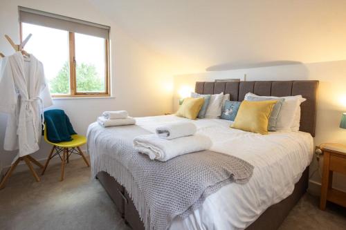 a bedroom with a large bed with towels on it at Waters Edge 04, Waterside Lodge P in South Cerney