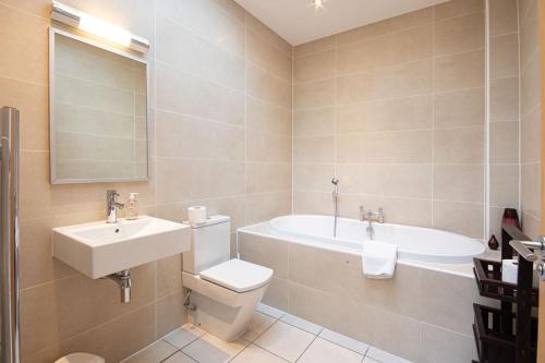 a bathroom with a sink and a toilet and a tub at Waters Edge 04, Waterside Lodge P in South Cerney