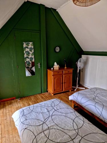 - une chambre avec 2 lits et un mur vert dans l'établissement Maison de campagne à 15 km du ZooParc de Beauval, à Luçay-le-Mâle