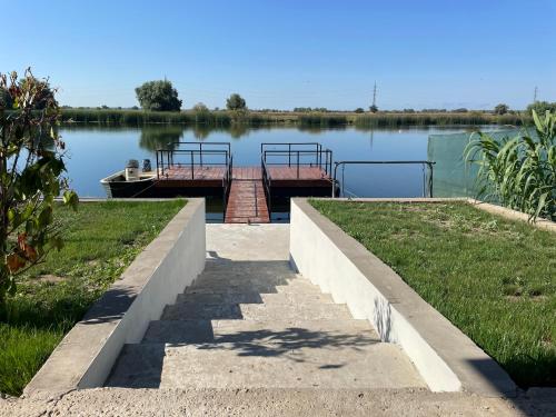 a dock with a boat in the middle of a lake at Casa Nicola in Mila Douăzeci şi Trei