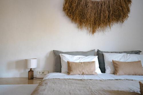 a bedroom with a large bed with white pillows at Oasis Living Can Nirvana - Best Sea Sunsets in Cala Tarida