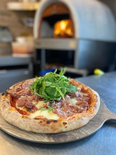 a pizza sitting on top of a plate on a table at Hassop Station rooms on the Monsal Trail in Bakewell