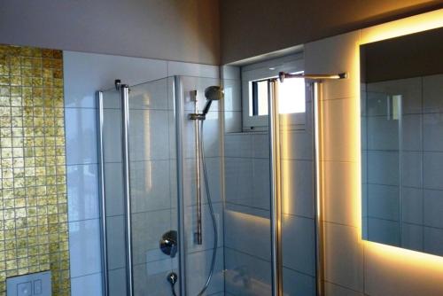 a bathroom with a shower with a glass door at Hochbehälter Ockerwitz in Dresden