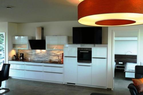 a kitchen with white cabinets and a flat screen tv at Hochbehälter Ockerwitz in Dresden