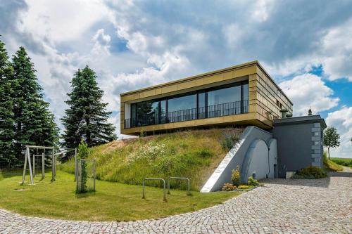 a house on top of a grassy hill with a building at Hochbehälter Ockerwitz in Dresden