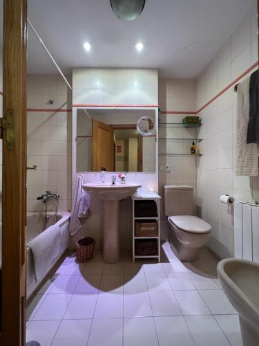 a bathroom with a sink and a tub and a toilet at Apartamento Posada de Llanes in Posada
