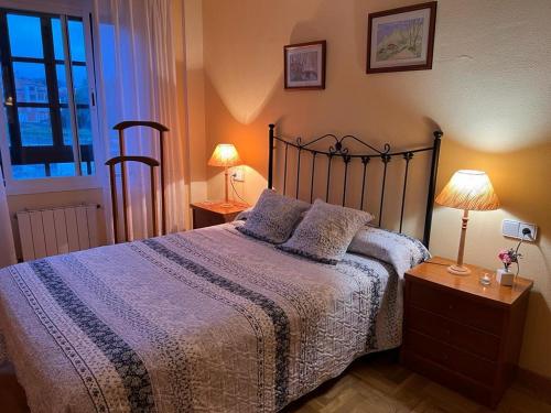 PosadaにあるApartamento Posada de Llanesのベッドルーム1室(ベッド1台、ランプ2つ、窓付)