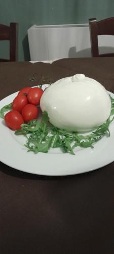 a plate with tomatoes and an egg on a table at B&B Tenuta San Michele in Capaccio-Paestum