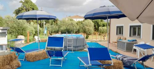 a group of blue chairs and umbrellas in a yard at B&B Tenuta San Michele in Capaccio-Paestum