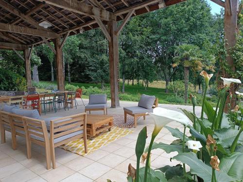 a patio with tables and chairs and a pavilion at Gîte Les Hauts de Marère in Sévignacq-Meyracq