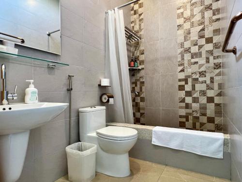 ein Bad mit einem WC, einem Waschbecken und einer Dusche in der Unterkunft 墾丁夏林灣民宿 包棟Villa-停車場-烤肉-近墾丁大街-大灣沙灘 in Kenting
