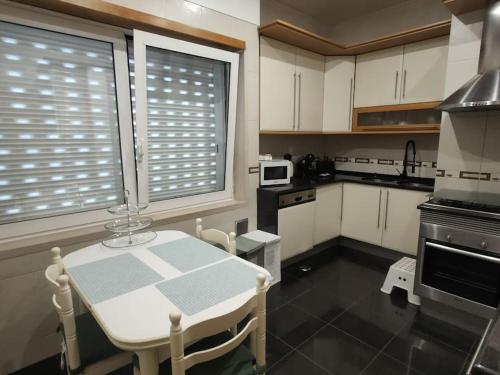 a kitchen with a table and a kitchen with white cabinets at Sweet Little Orange in Lisbon