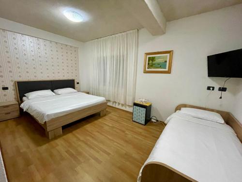 a bedroom with two beds and a flat screen tv at River Side in Statiunea Borsa