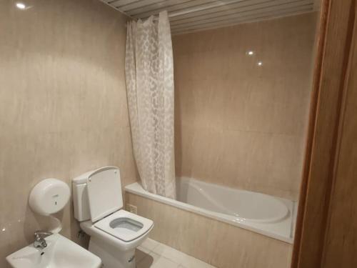 a bathroom with a toilet and a bath tub at Sweet Little Orange in Lisbon