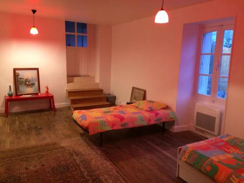 een kamer met 2 bedden en een trap erin bij Gîte des Lavandières en bordure de Vienne (Civaux) 