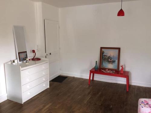 Habitación blanca con tocador blanco y mesa roja en Gîte des Lavandières en bordure de Vienne (Civaux), 