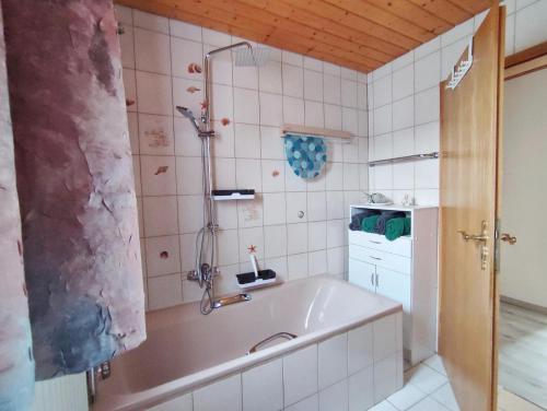 a bathroom with a tub and a sink at Ferienhaus Blick Falkenstein in Lindberg