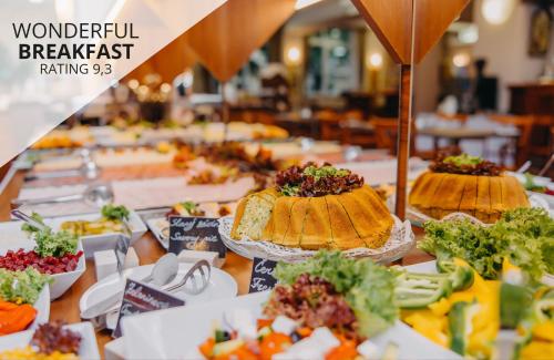 una mesa cubierta con muchos tipos diferentes de comida en Hotel Adler - Czech Leading Hotels, en Praga