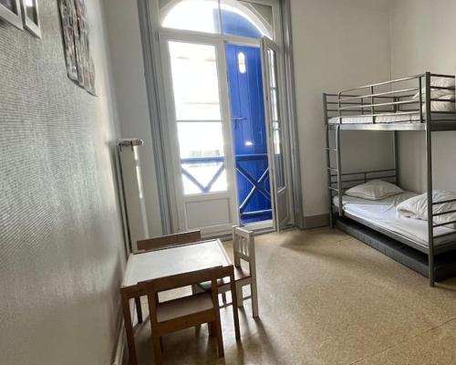 Cette chambre comprend 2 lits superposés, une table et un bureau. dans l'établissement VILLA ST SOPHIE, à Wimereux