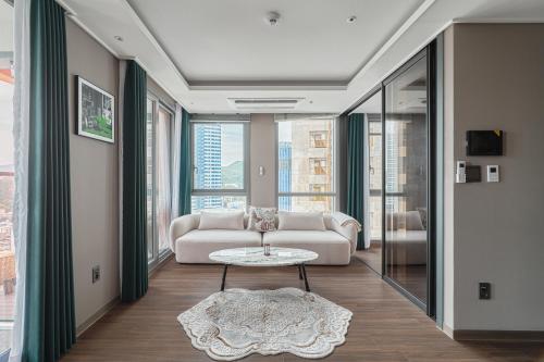 Sienna Ambassador Residence في بوسان: غرفة معيشة مع أريكة وطاولة